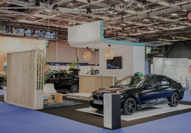 Un salon automobile avec un véhicule noir et un espace d'exposition moderne.